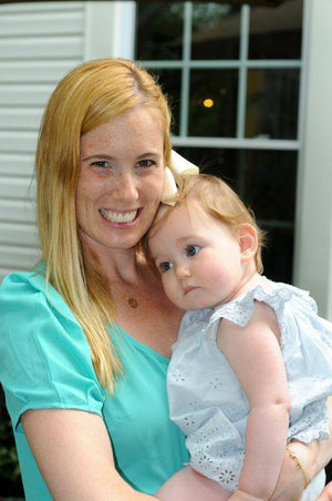 Picture of Jessica, co-founder of unique toddler clothing brand Worthy Threads, holding her baby