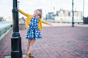 Girl in hedgehog dress hanging from lamp post. Hedgehog baby clothes available, perfect for matching sister outfits newborn and toddler!  Unique toddler clothes