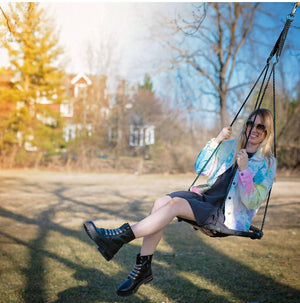 Girl on swing wearing tie dye denim jacket