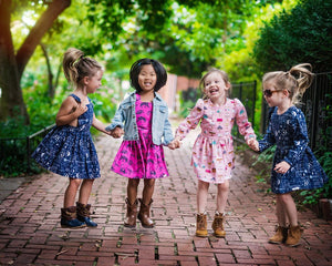 Unique kids clothes.  Four girls in vintage style dresses holding hands and jumping.  Matching sibling outfits available!
