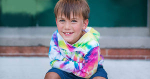 boy smiling in worthy threads tie dye hoodie