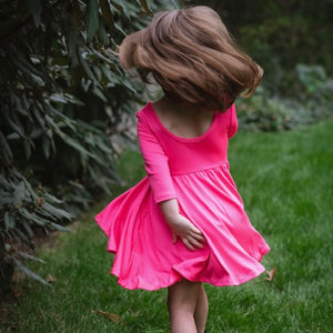 Toddler twirling in hot pink twirly dress