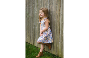 Toddler modeling ruffle sleeve dress in purple flowers print