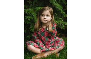 Girl wearing christmas dress in green red holiday plaid