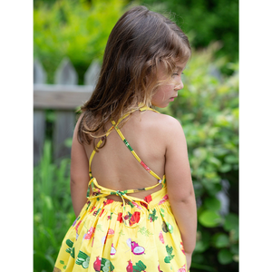 Back view of girls tie back dress in veggie print