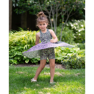 Girl twirling in cross back twirly dress, neon leopard