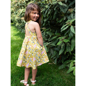 Back view of girls cross back dress in funky dogs print with pockets