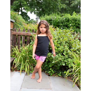 Toddler modeling hot pink biker shorts with dinosaur print: stem clothing for girls