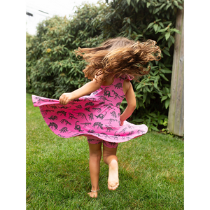 Girl in matching pink dinosaur outfit: biker shorts and twirly dress