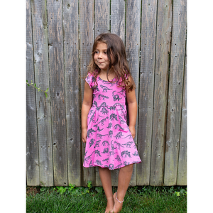 Girl modeling hot pink dinosaur dress with ruffle sleeves