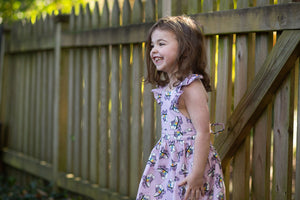 Model in girls purple ruffle sleeve dress with roller skates print