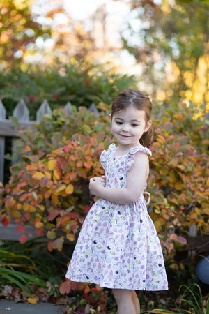 Toddler in ruffle sleeve dress featuring 90s toys