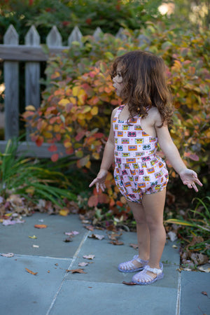 Toddler in pink cross back bubble romper in retro print