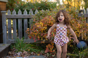 Toddler in pink retro print cross back bubble romper