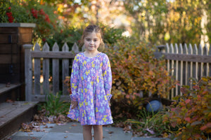 Model in purple long sleeve dress featuring balloon animals