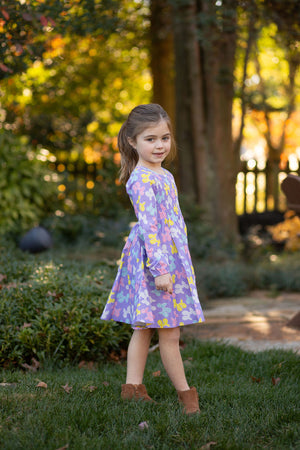 Model in purple ruched dress with balloon animals