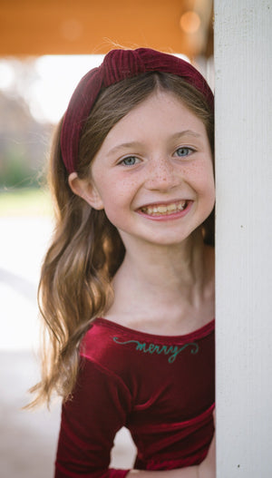 Toddler in Christmas velvet dress with Merry embroidered at neckline