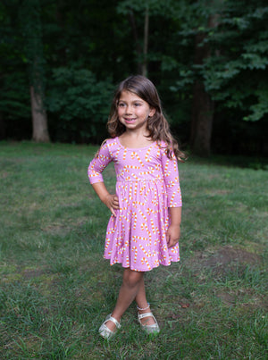 Model in girls twirly christmas dress in pink candy cane print