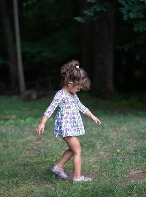 Side view of Toddler in baby bubble romper featuring retro funky sneakers print