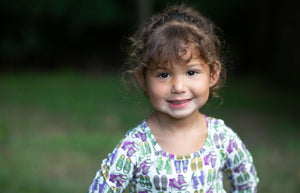 Close up of Toddler in baby bubble romper featuring retro funky sneakers print