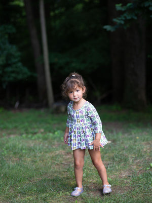 Front view of Toddler in baby bubble romper featuring retro funky sneakers print