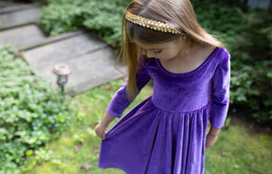 Toddler wearing girls twirly dress in eggplant purple stretch velvet