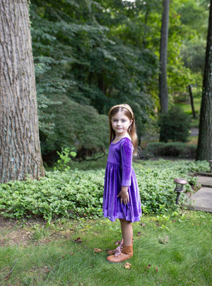 Toddler wearing girls twirly dress in eggplant purple stretch velvet, side view