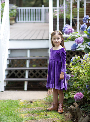 Toddler wearing girls twirly dress in eggplant purple stretch velvet, front view