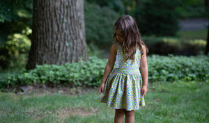 Toddler modeling girls pinafore dress in cheetah print