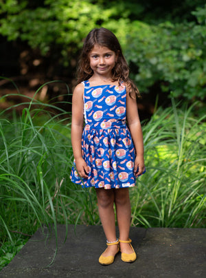 Toddler modeling girls pinafore dress in funky fun blue ramen print, front view