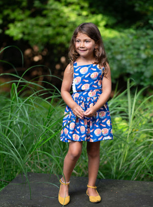 Toddler modeling girls pinafore dress in funky fun blue ramen print, apron dress