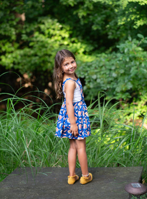 Toddler modeling girls pinafore dress in funky fun blue ramen print, side view