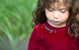 Christmas holiday velvet bubble romper with embroidery modeled by toddler, zoomed in on embroidery