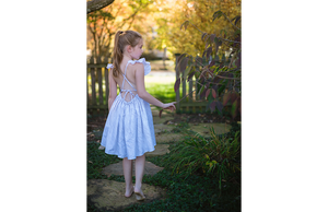 Back view of girl modeling ruffle sleeve dress in light zebra print