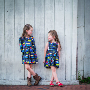 Girls modeling matching dress in boombox print. Retro dresses in matching sibling outfits