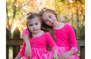 Girls in matching hot pink velvet twirly dresses