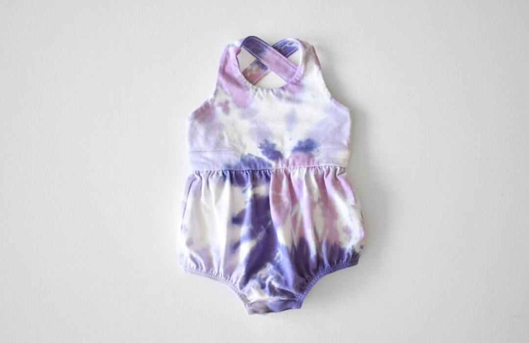 Baby bubble romper in purple tie dye: cross back design