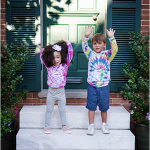 Tie dye baby clothes by Worthy Threads clothing brand!  Girl wearing pink and purple tie dye raglan and boy in tie dye hoodie with hands raised.  Unique toddler clothes