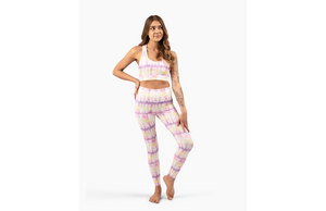 Model in sunset tie dye activewear set: pastel leggings and sports bra