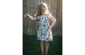 Model in colorful veggie print ruffle sleeve dress flipping her hair